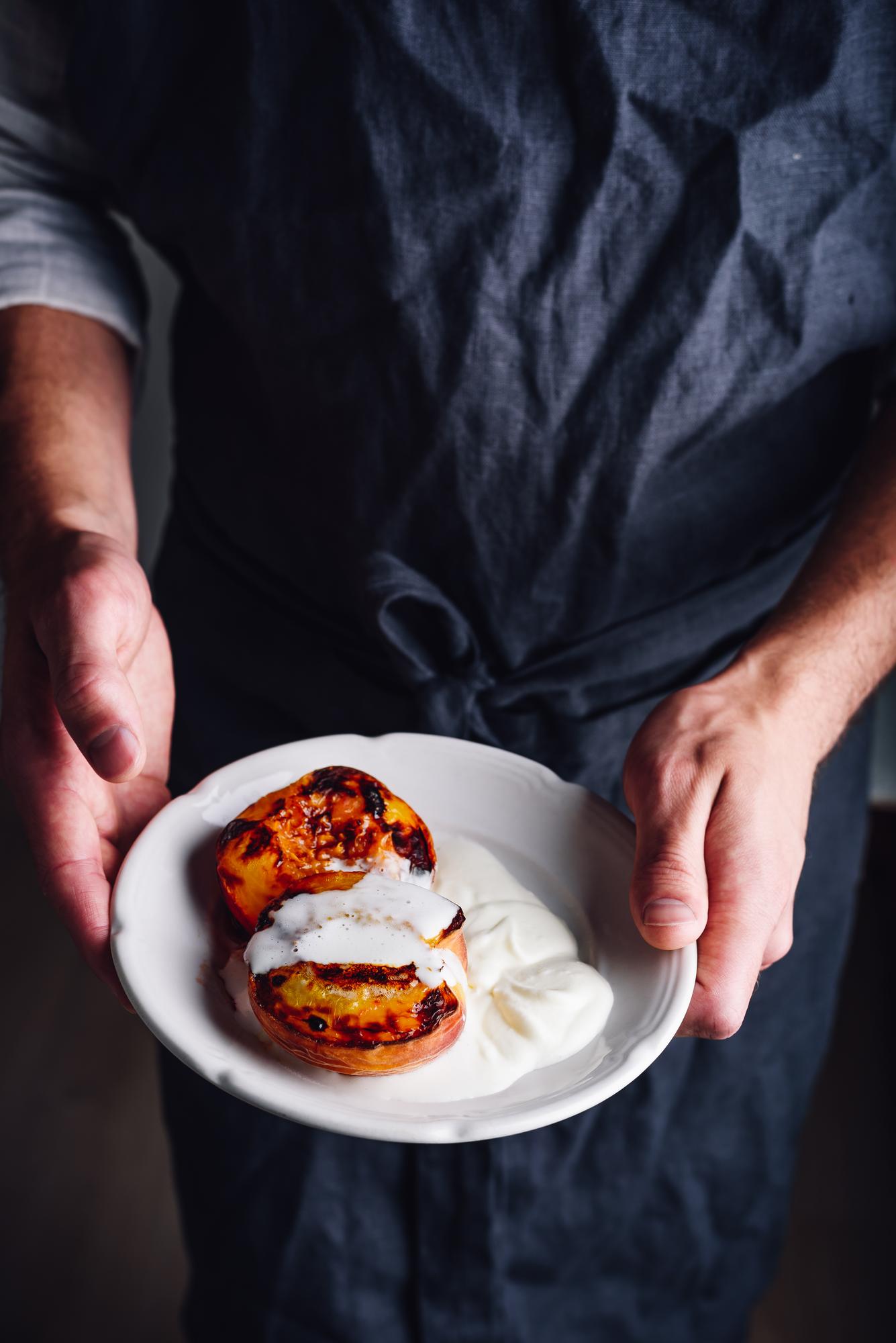 Instructor plating a crafted dish in a warm kitchen